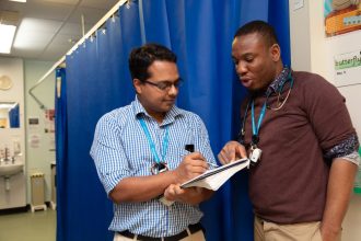 Photo of two doctors talking on the ward