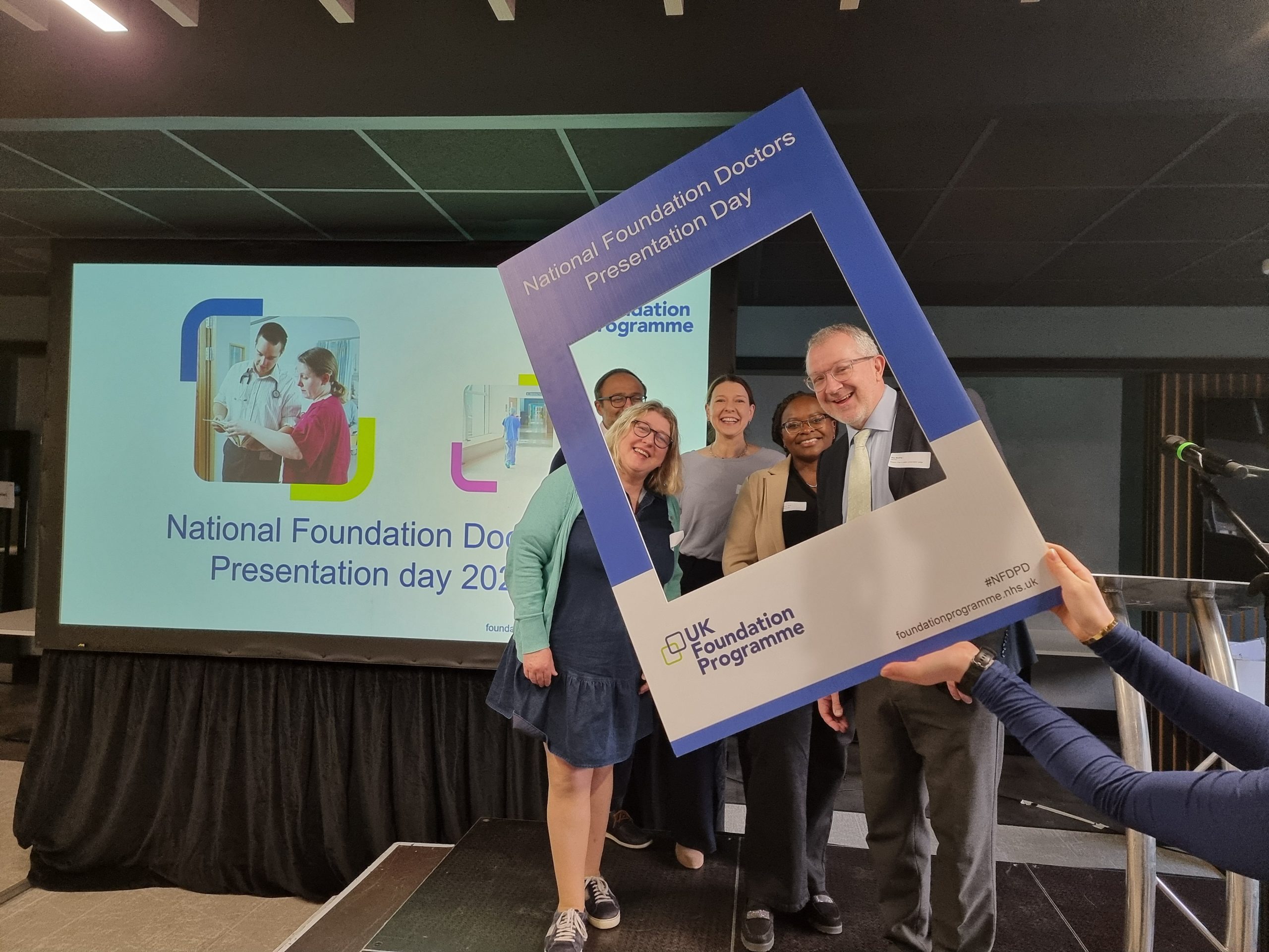 Image of foundation faculty on the podium using the NFDPD selfie frame