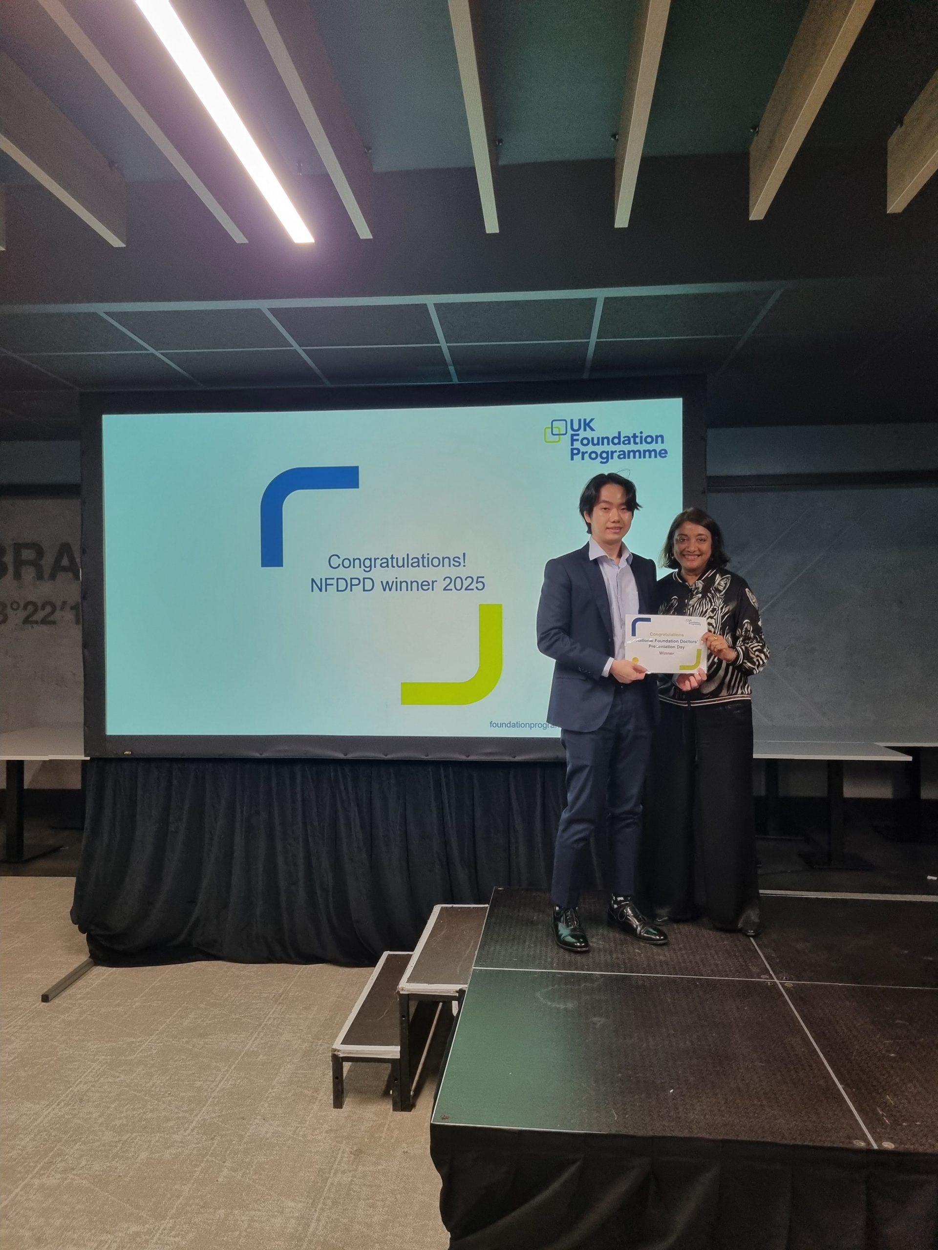 Image of Dr Jun Jie Lim winner of their presentation group receiving their certificate presented by Dr Navina Evans