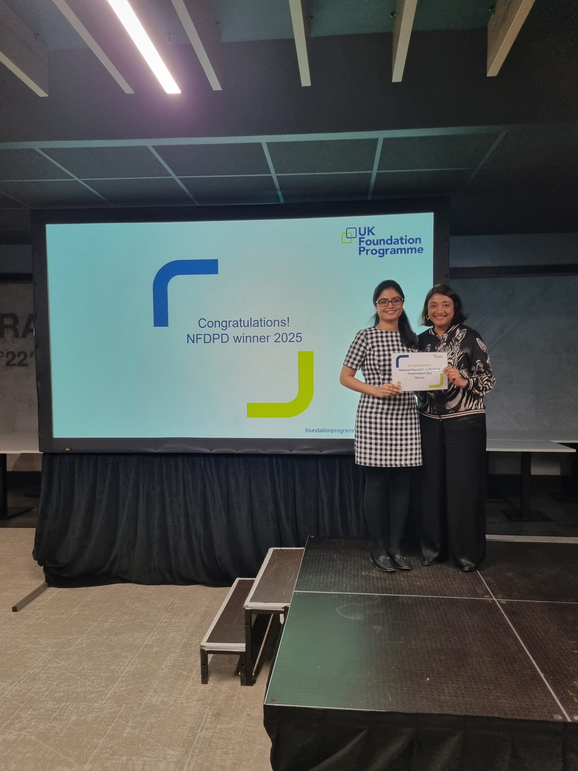 Image of Dr Nothiga Kumarakulasingham winner of their presentation group receiving their certificate presented by Dr Navina Evans