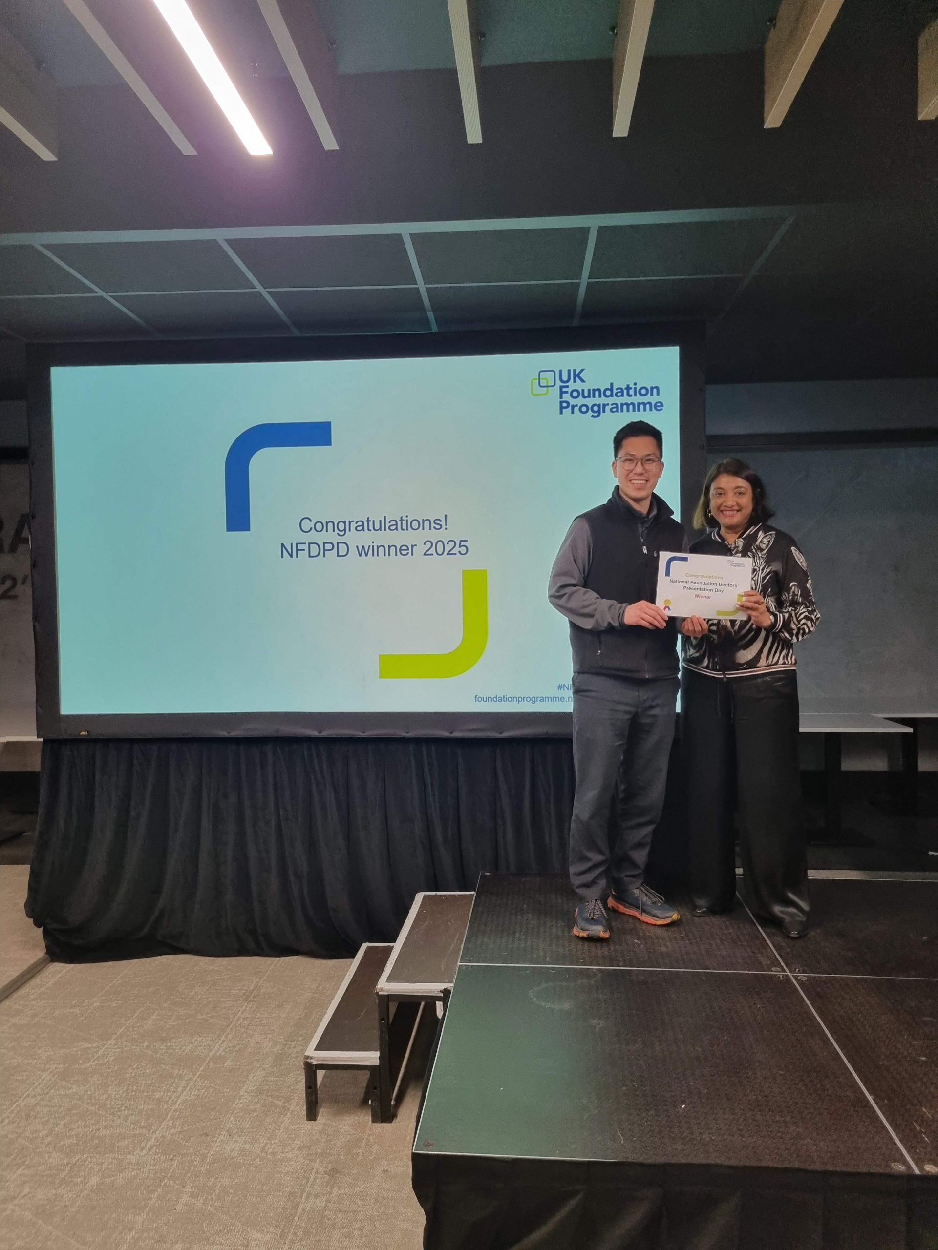 Image of Dr Victor Lim winner of their presentation group receiving their certificate presented by Dr Navina Evans