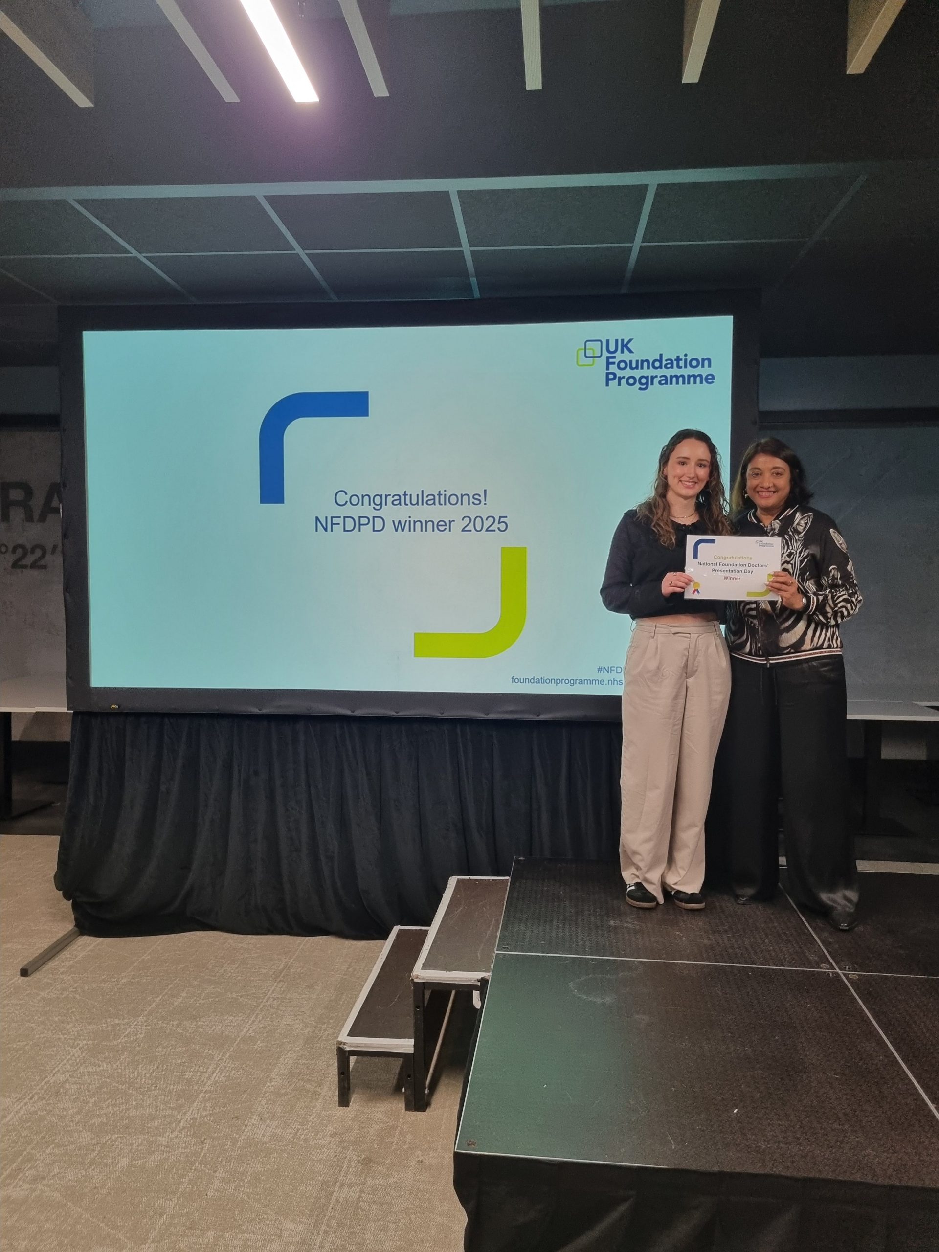 Image of Dr Abbie Green runner up of their presentation group receiving their certificate presented by Dr Navina Evans