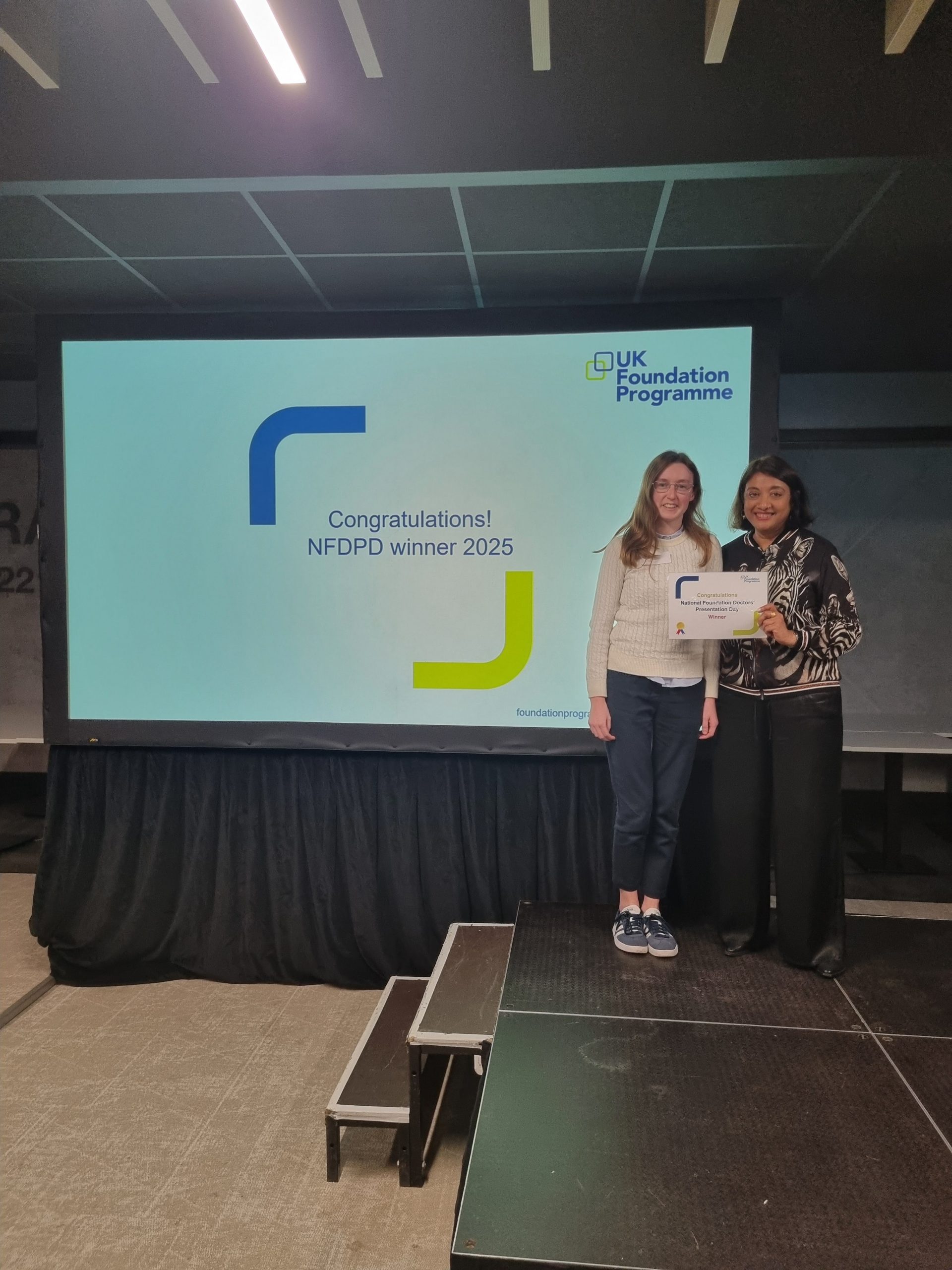 Image of Dr Beatrix Banks runner up of their presentation group receiving their certificate presented by Dr Navina Evans