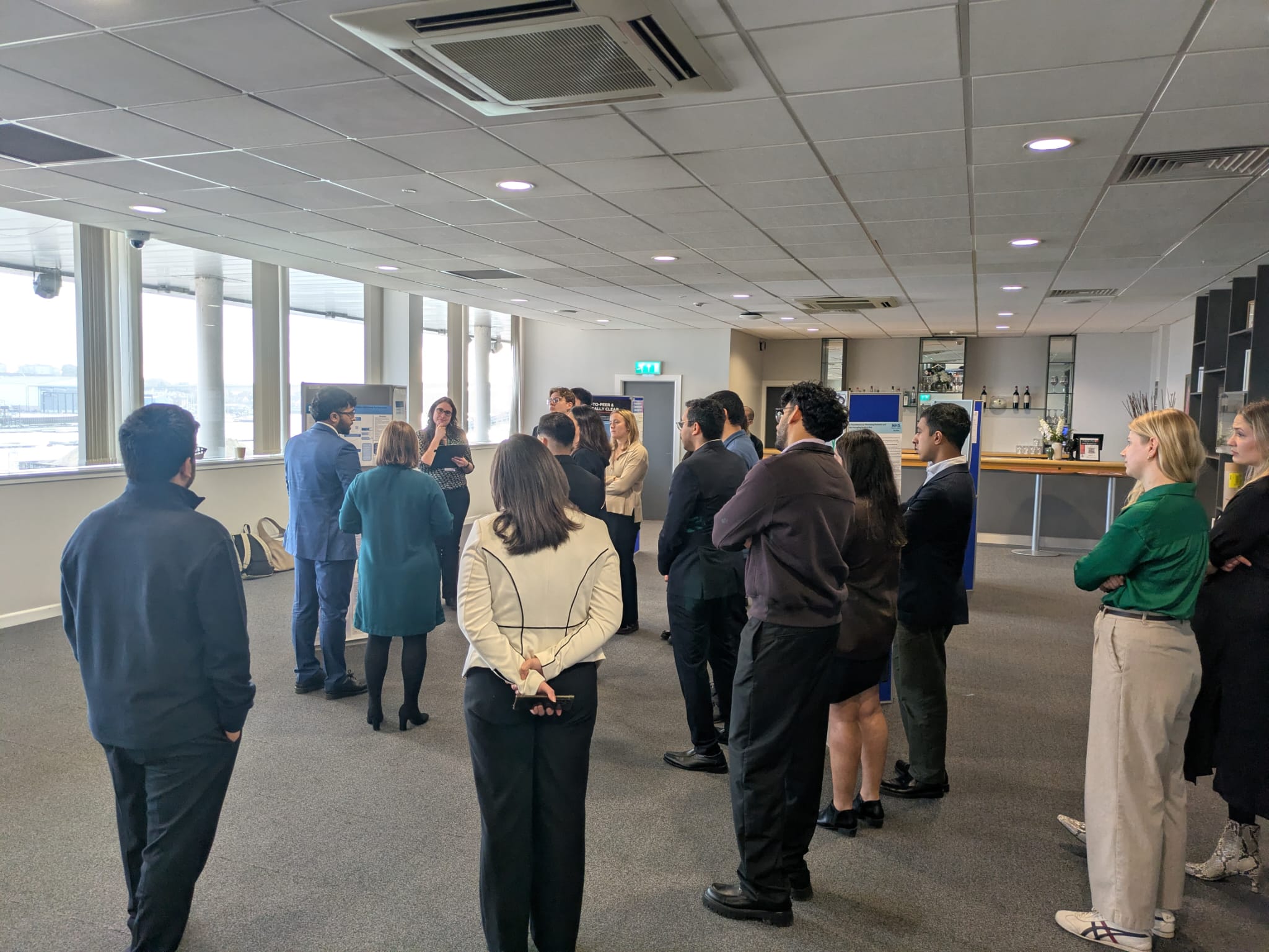 Image of foundation doctors listening to a poster board presentation