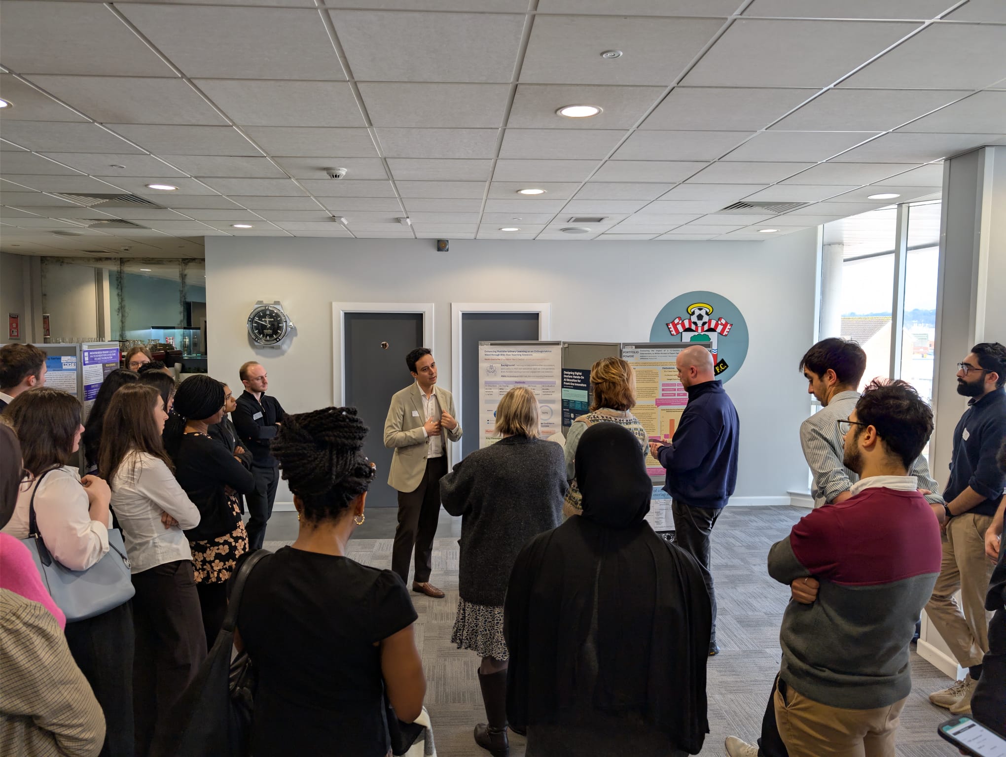 Image of foundation doctors listening to a poster board presentation