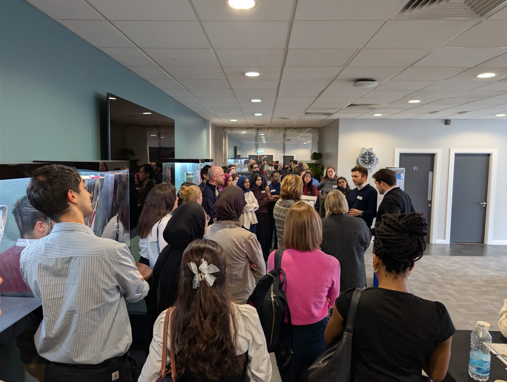 Image of foundation doctors listening to a poster board presentation