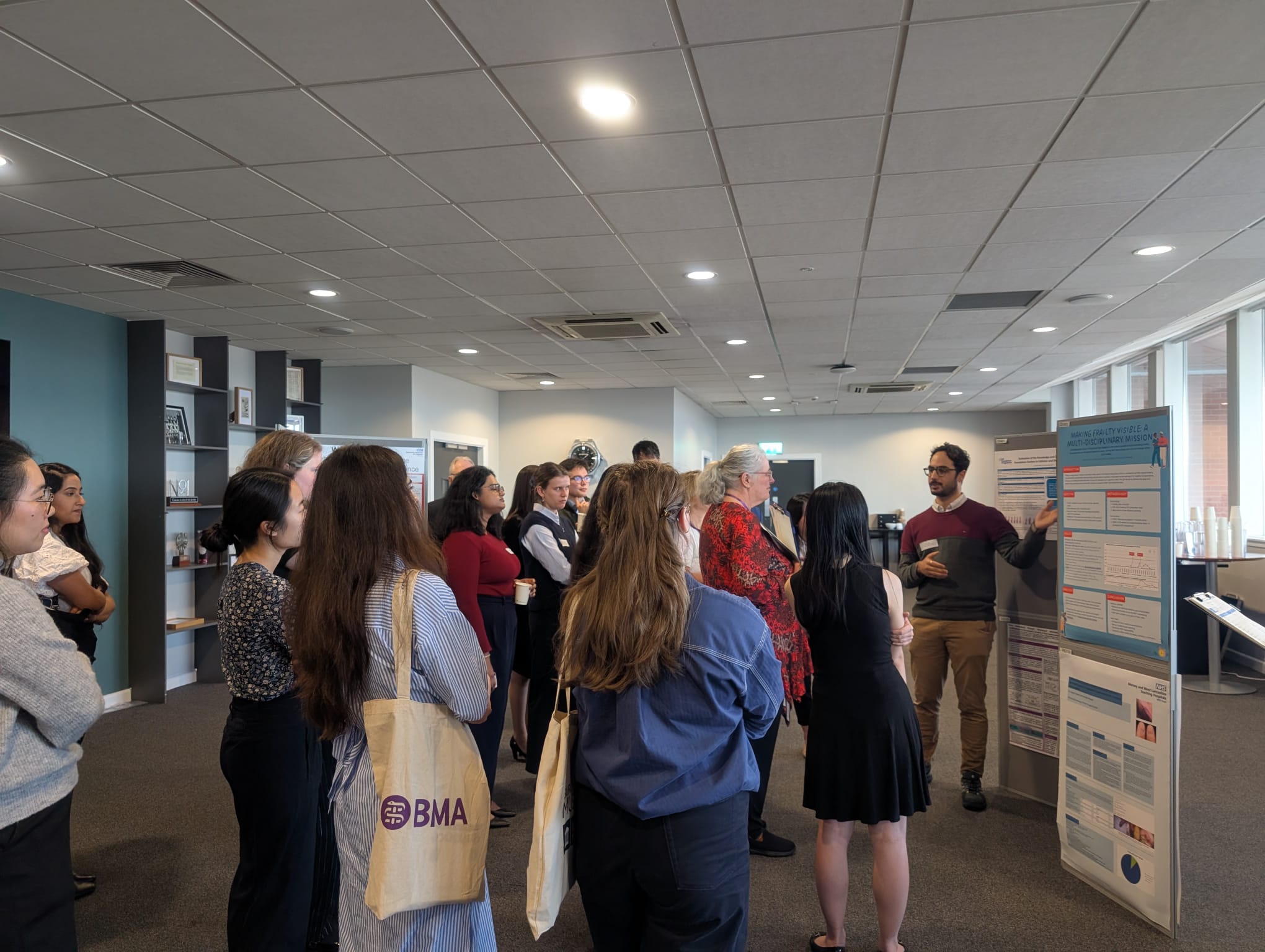 Image of foundation doctors listening to a poster board presentation