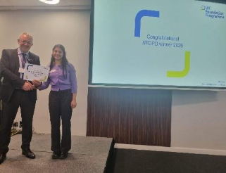 Image of Dr Hateem Rafeequq winner of their presentation group receiving their certificate presented by Dr Mike Masding 