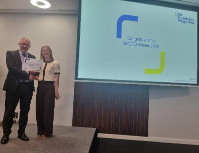 Image of Dr Samantha Barker winner of their presentation group receiving their certificate presented by Dr Mike Masding 