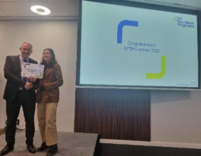 Image of Dr Lisa Abrahim winner of their presentation group receiving their certificate presented by Dr Mike Masding