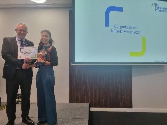 Image of Dr Minna Chang winner of their presentation group receiving their certificate presented by Dr Mike Masding 