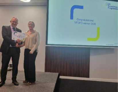 Image of Dr Juliet Banks winner of their presentation group receiving their certificate presented by Dr Mike Masding 