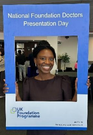 Image of Dr Michelle Gladstone winner of their presentation group taking a picture with the NFDPD selfie frame