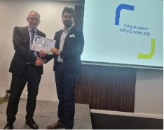 Image of Dr Jeevtesh Soni winner of their presentation group receiving their certificate presented by Dr Mike Masding 