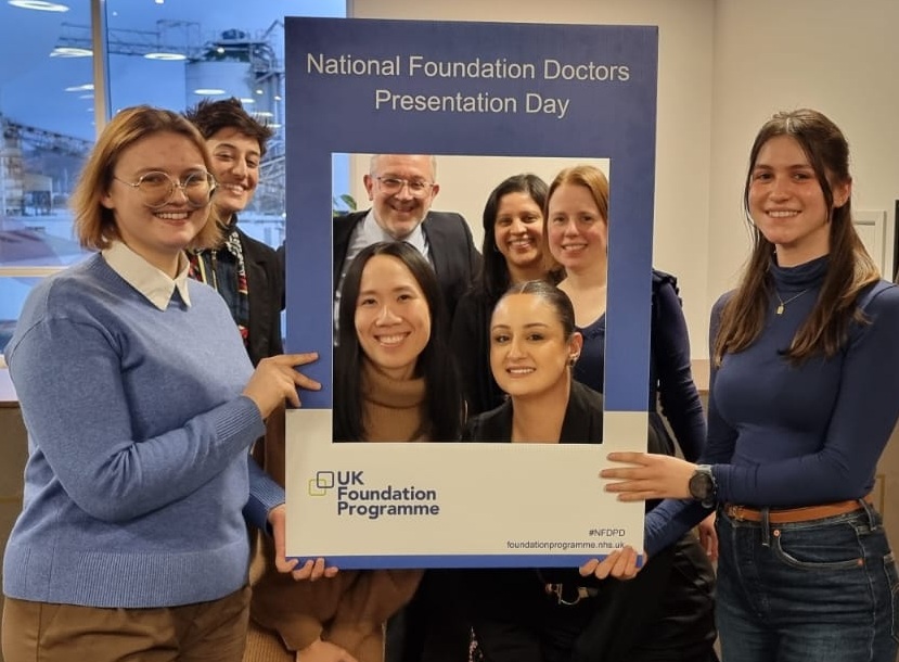 Image of UKFPO team and Fellows taking a picture with NFDPD selfie frame